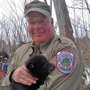 Photo of Chris Anchor with a bear cub